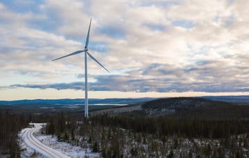 Ett vindkraftverk i skogslandskap en vinterdag