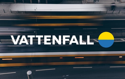 Vattenfall‑logotyp över suddig flygvy av flerfilig trafik.