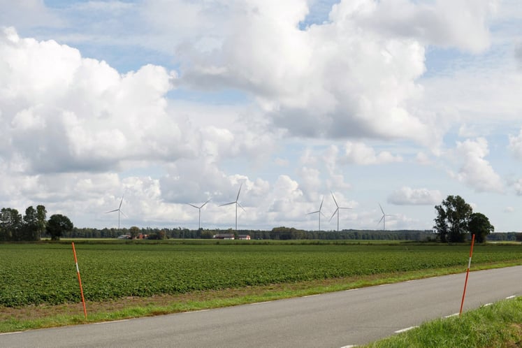 En väg med vindkraftverk i bakgrunden En väg med vindkraftverk i bakgrunden