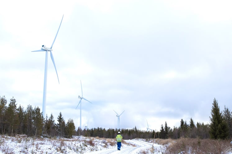 En Vattenfallmedarbetare går på en väg utmed en vindkraftspark En Vattenfallmedarbetare går på en väg utmed en vindkraftspark
